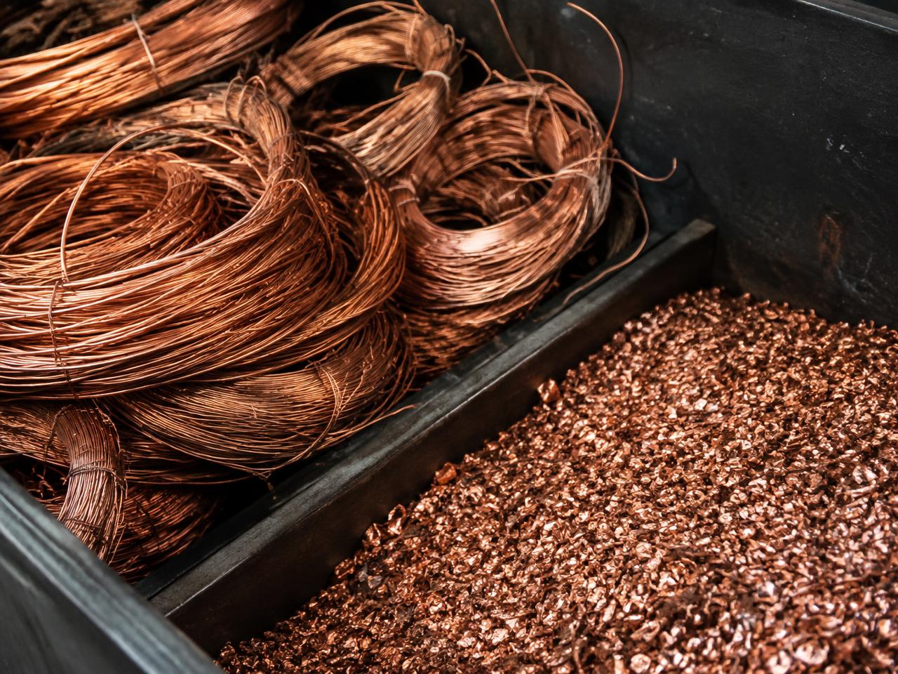 Sorted bright copper wire coils and copper granules in a sorting bin